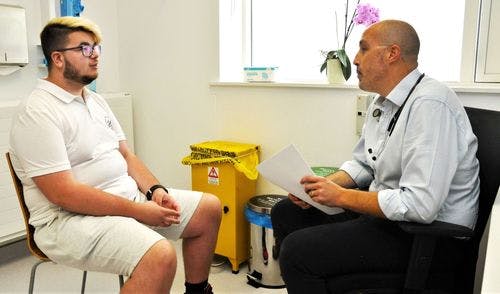 A man sitting in a chair talking to a doctor.2548.jpg